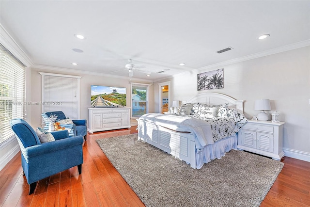 bedroom featuring ceiling fan, hardwood / wood-style flooring, and multiple windows