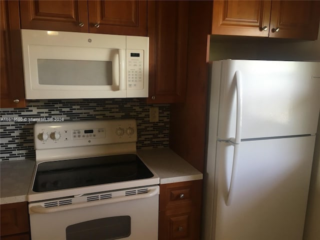 kitchen with backsplash and white appliances