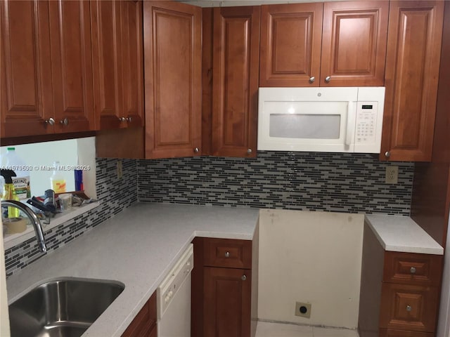 kitchen with tasteful backsplash, white appliances, and sink