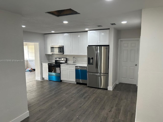 kitchen featuring stainless steel appliances, dark wood-style flooring, a sink, and white cabinets