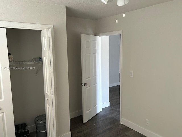 unfurnished bedroom with dark wood-style flooring and baseboards