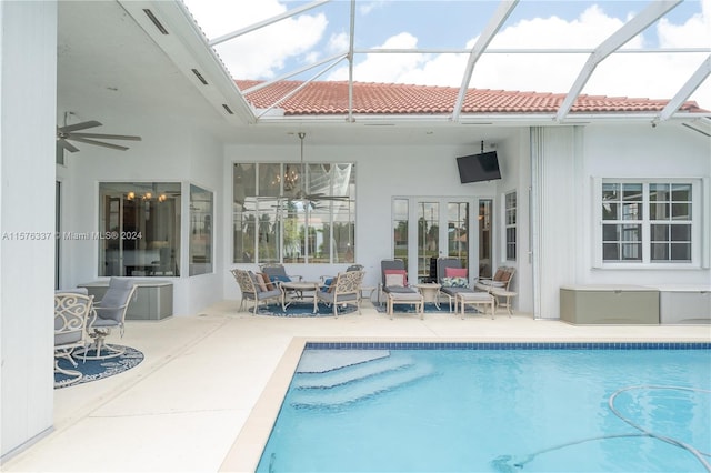 back of property with a tile roof, a patio area, ceiling fan, glass enclosure, and an outdoor pool