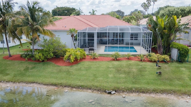 rear view of property with an outdoor pool, a lawn, glass enclosure, a tile roof, and stucco siding