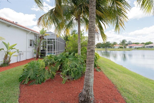 view of yard featuring glass enclosure and a water view