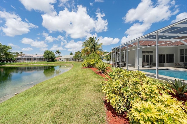 view of yard with a water view, glass enclosure, and an outdoor pool