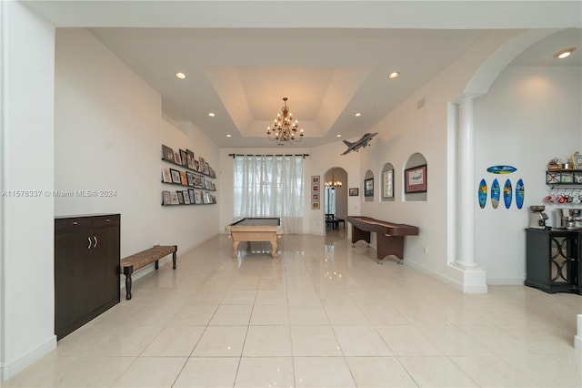 interior space featuring arched walkways, recessed lighting, a tray ceiling, and an inviting chandelier