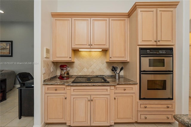 kitchen featuring backsplash, double oven, light tile patterned flooring, light brown cabinets, and black electric cooktop