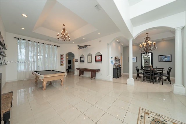 recreation room with ornate columns, light tile patterned floors, a tray ceiling, and a chandelier