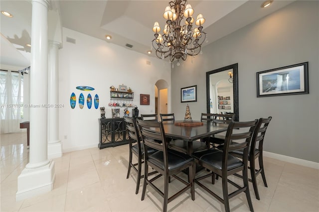 dining area with decorative columns, arched walkways, a raised ceiling, baseboards, and light tile patterned flooring