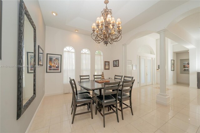 dining space featuring decorative columns, light tile patterned floors, and an inviting chandelier