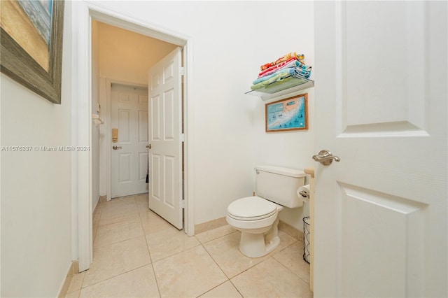 bathroom with tile patterned flooring, toilet, and baseboards