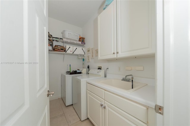 washroom featuring light tile patterned floors, independent washer and dryer, a sink, and cabinet space