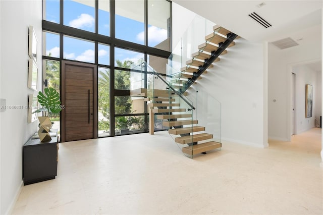 entrance foyer featuring a towering ceiling and a wealth of natural light