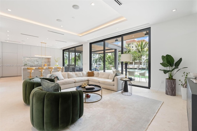 living room featuring a raised ceiling and a wall of windows