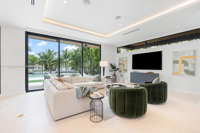 living room with a raised ceiling and expansive windows