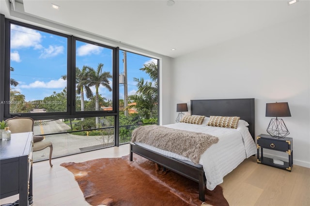 bedroom featuring light hardwood / wood-style flooring and expansive windows