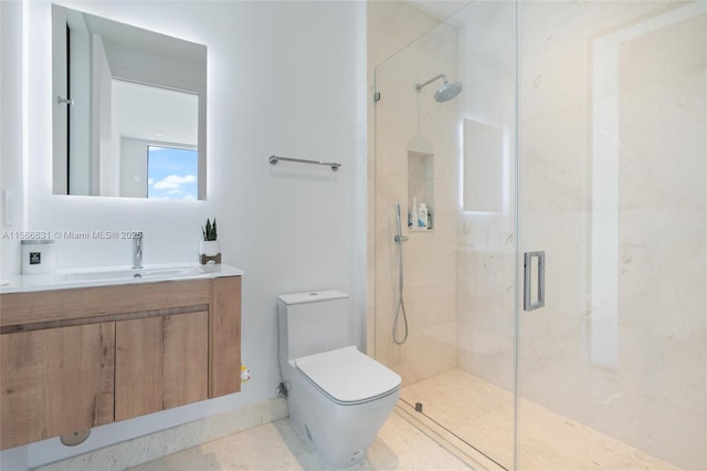 bathroom with vanity, a shower with shower door, and toilet