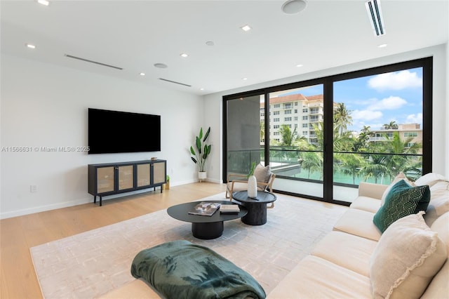 living room with floor to ceiling windows and light wood-type flooring