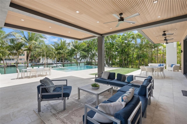 view of patio featuring a water view, ceiling fan, and an outdoor hangout area