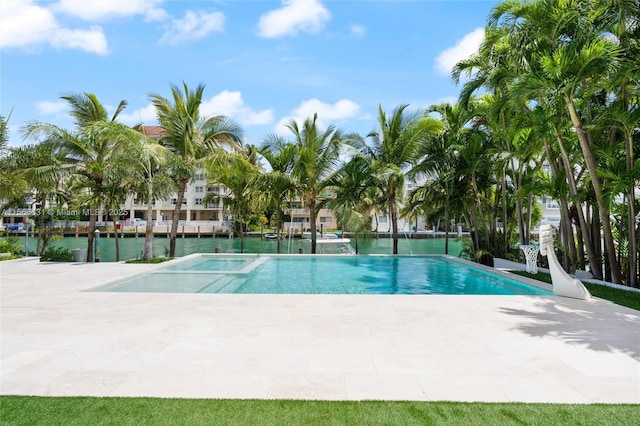 view of pool with a water view and a patio area