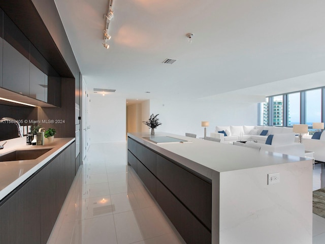 kitchen featuring a kitchen island, sink, light tile floors, and track lighting