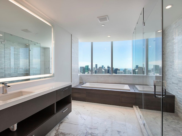 bathroom with tile floors, independent shower and bath, and large vanity