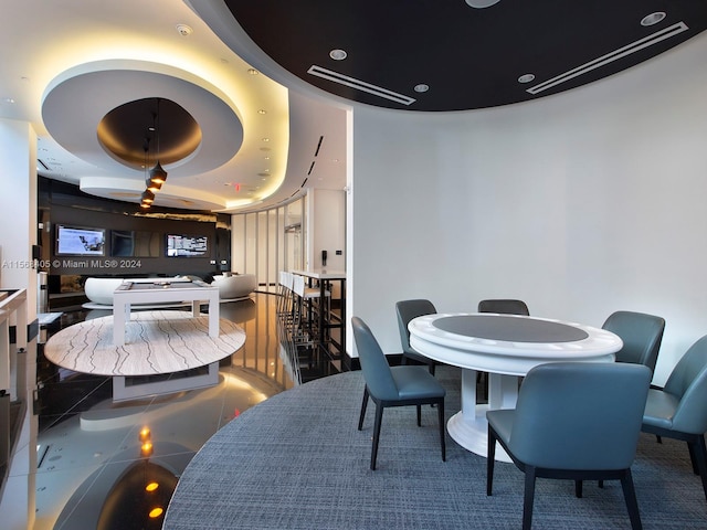 tiled dining area with a raised ceiling