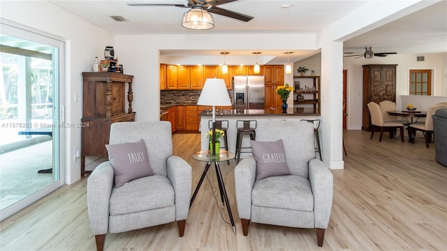 living area featuring ceiling fan and light wood-type flooring