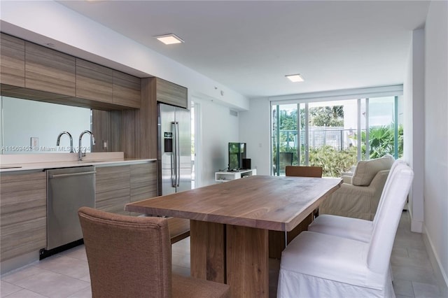 kitchen featuring sink, light tile floors, and stainless steel appliances