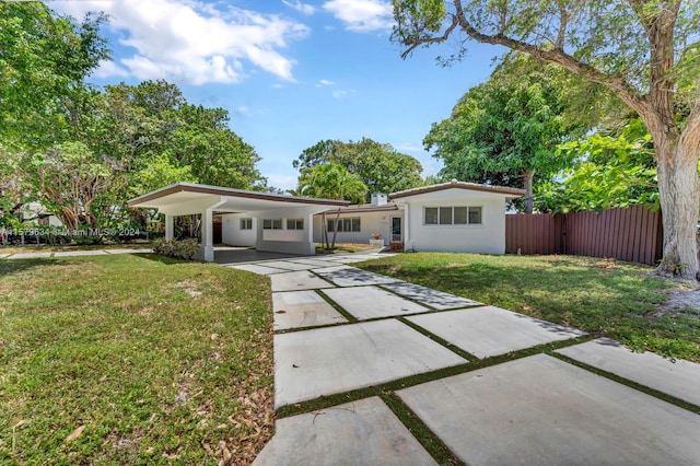 view of front of house featuring a carport and a front yard