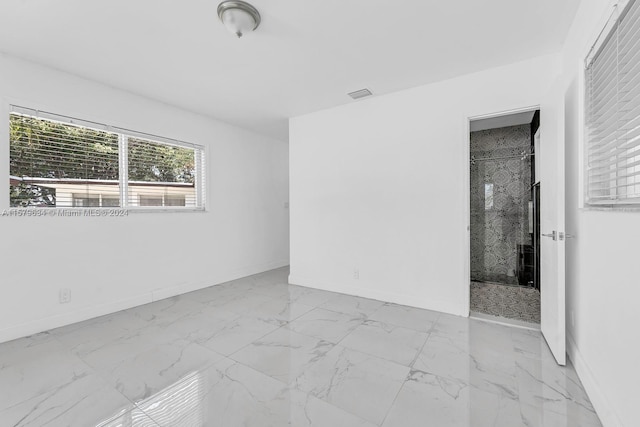 kitchen with backsplash, appliances with stainless steel finishes, white cabinetry, and light tile flooring