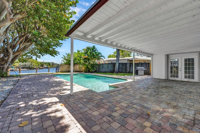 view of pool featuring grilling area, french doors, and a patio