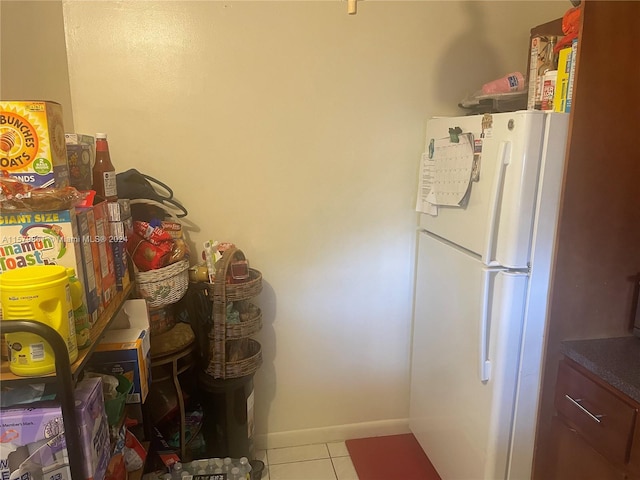 kitchen featuring white refrigerator and tile floors