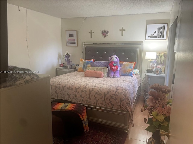 bedroom with a textured ceiling and tile flooring