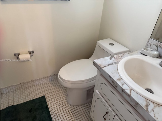 bathroom with tile patterned flooring, vanity, and toilet