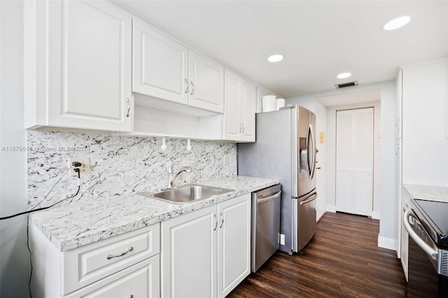 kitchen with tasteful backsplash, sink, white cabinets, appliances with stainless steel finishes, and dark hardwood / wood-style flooring