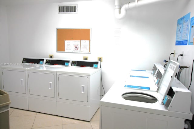 washroom with independent washer and dryer and light tile patterned floors