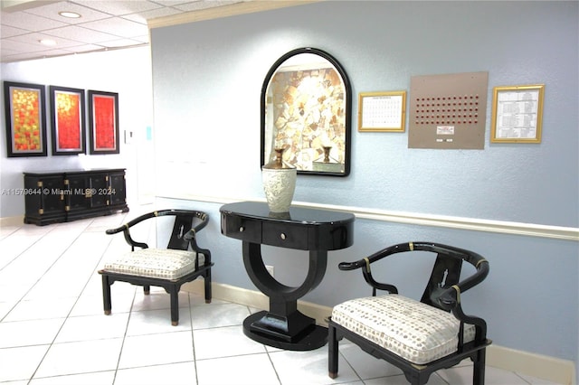 sitting room with light tile patterned floors and a paneled ceiling