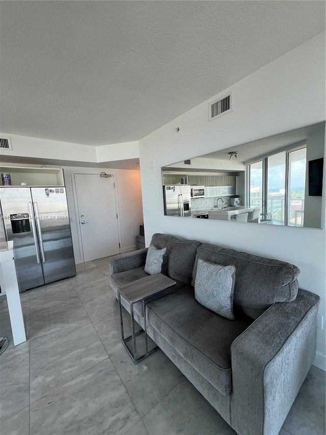 living room featuring sink and light tile floors