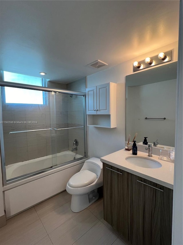 full bathroom featuring shower / bath combination with glass door, vanity, toilet, and tile flooring