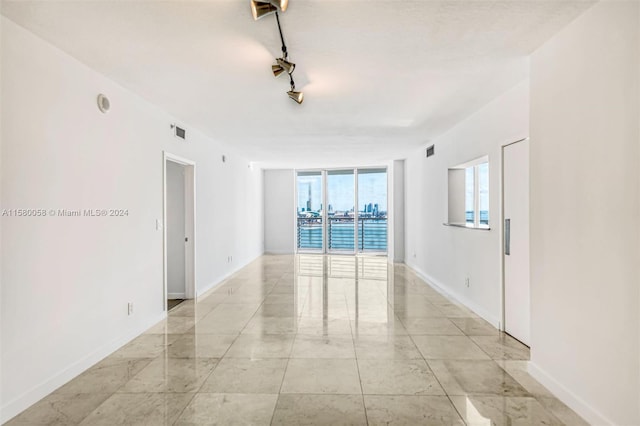 unfurnished room with track lighting