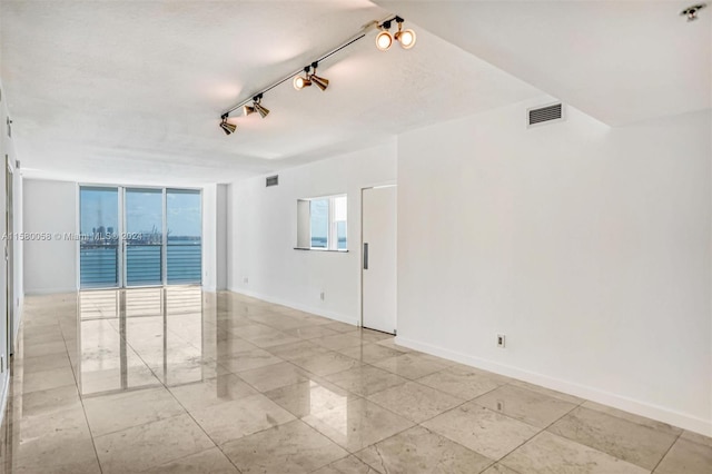 unfurnished room featuring track lighting