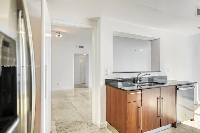 kitchen featuring dark stone countertops, sink, and appliances with stainless steel finishes