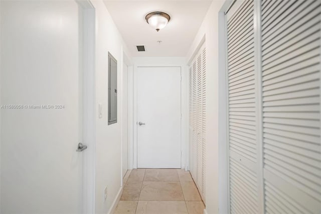 corridor featuring light tile patterned floors and electric panel