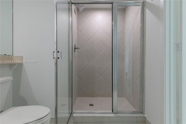 bathroom featuring an enclosed shower and toilet