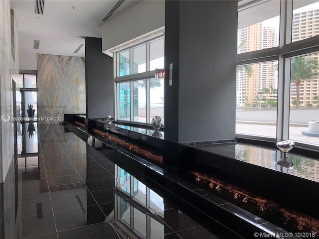 interior space with dark tile patterned floors and tile walls