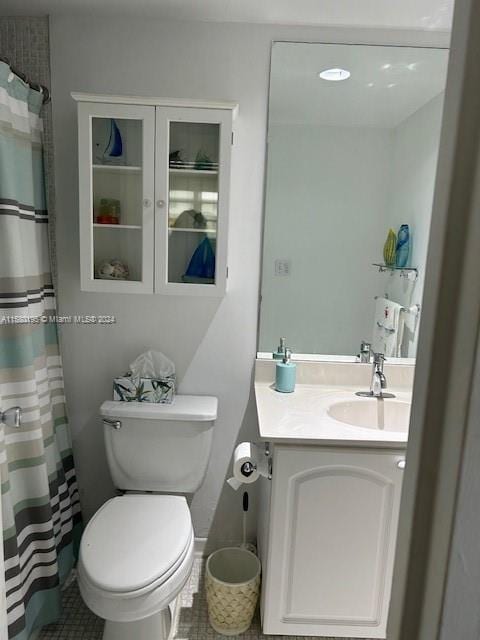 bathroom featuring toilet, tile floors, and vanity