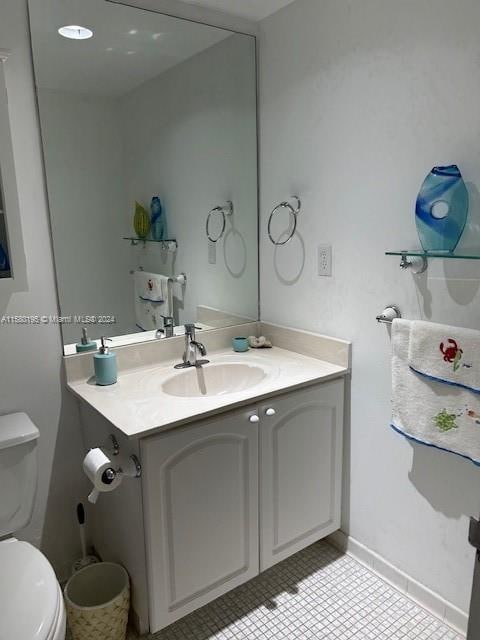 bathroom with vanity, toilet, and tile floors