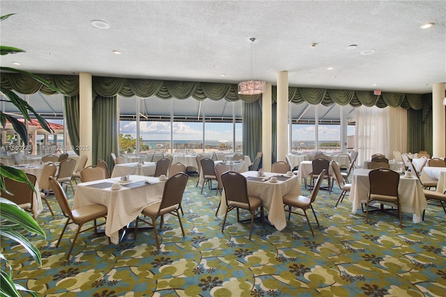 carpeted dining area with a textured ceiling