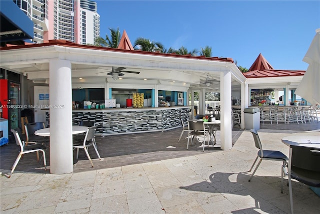 view of patio / terrace featuring ceiling fan and a bar